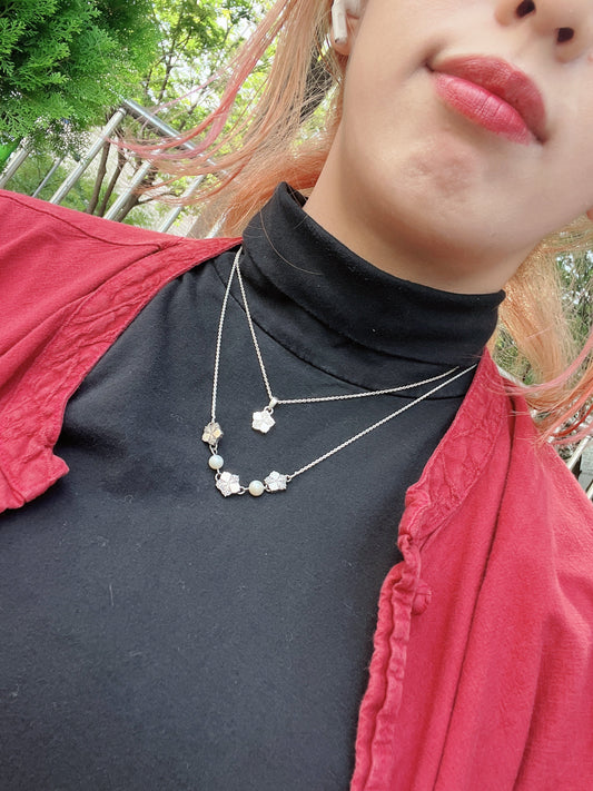 Plum Blossom Necklace layered over a turtleneck and modern hanbok