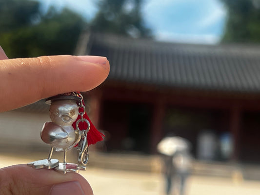 Handmade pearl duck charm captured on a walk around Seoul palaces, combining jewelry and heritage.